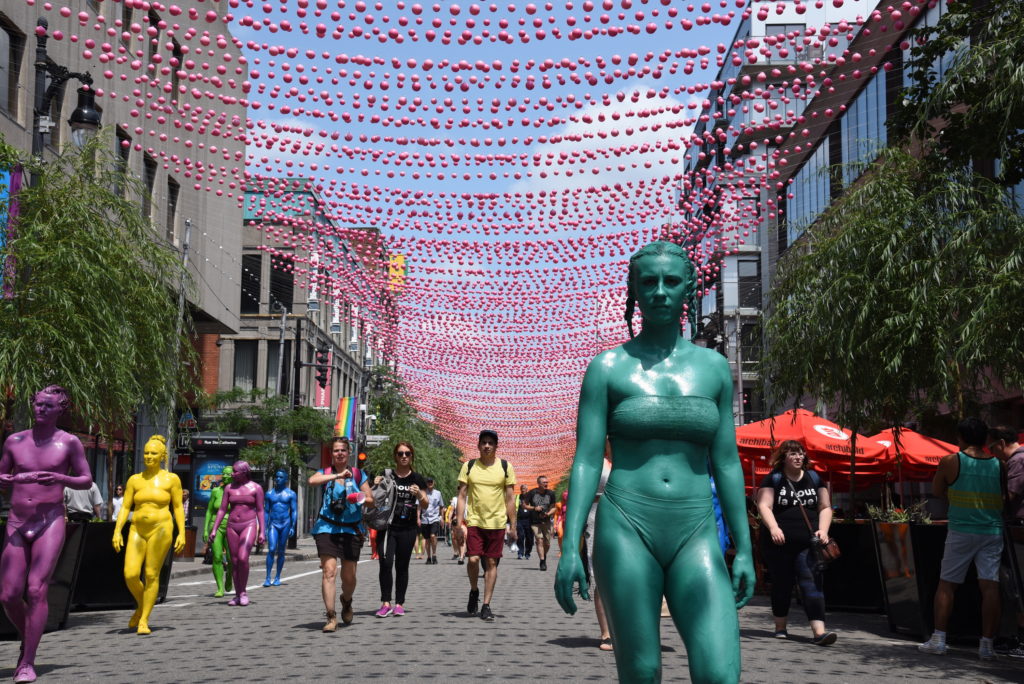 people in different colours of bodypaint, on the street
